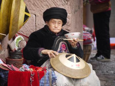 Minority woman in Fenghuang selling hats